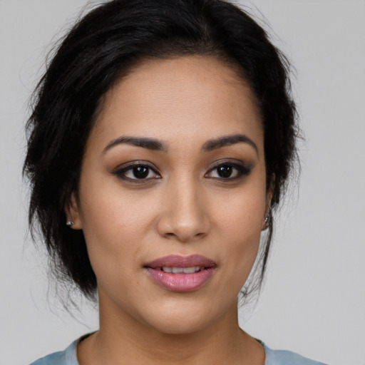 Joyful latino young-adult female with medium  brown hair and brown eyes
