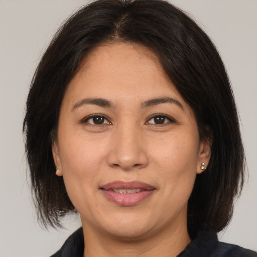 Joyful latino adult female with medium  brown hair and brown eyes