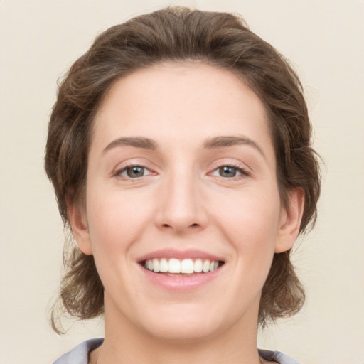 Joyful white young-adult female with medium  brown hair and green eyes