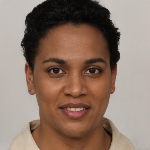Joyful black young-adult female with short  brown hair and brown eyes