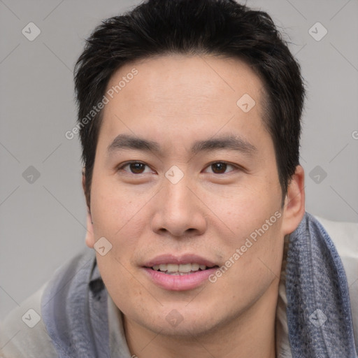 Joyful asian young-adult male with short  brown hair and brown eyes