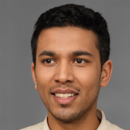 Joyful latino young-adult male with short  black hair and brown eyes