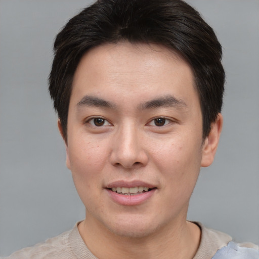 Joyful asian young-adult male with short  brown hair and brown eyes
