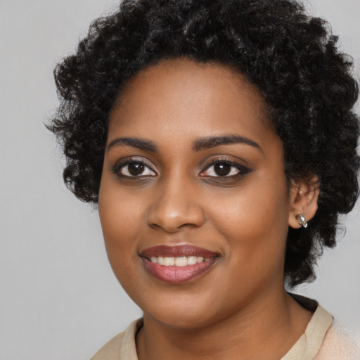 Joyful black young-adult female with long  black hair and brown eyes