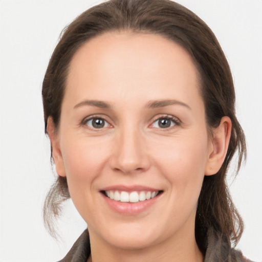 Joyful white young-adult female with medium  brown hair and grey eyes