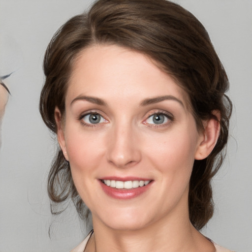 Joyful white young-adult female with medium  brown hair and grey eyes