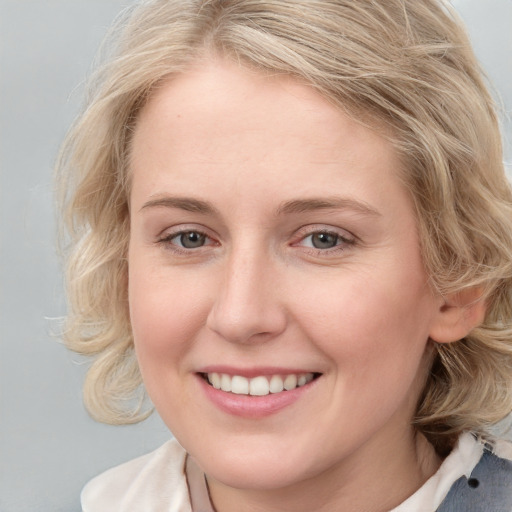 Joyful white young-adult female with medium  brown hair and blue eyes