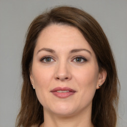 Joyful white adult female with long  brown hair and grey eyes