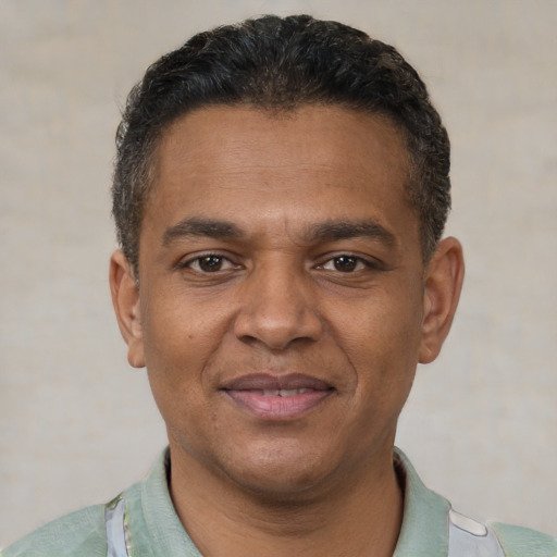 Joyful black adult male with short  black hair and brown eyes