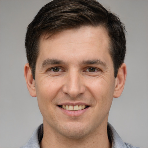 Joyful white young-adult male with short  brown hair and brown eyes