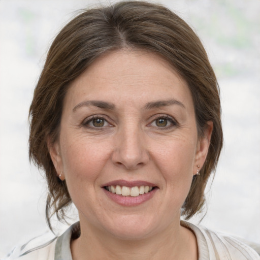 Joyful white adult female with medium  brown hair and grey eyes