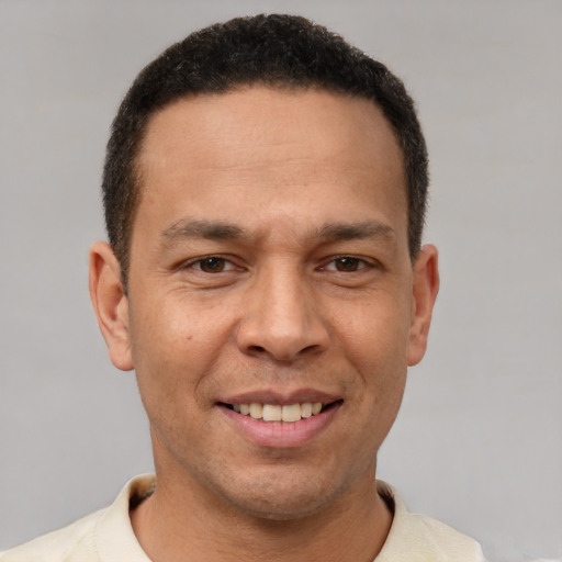 Joyful latino young-adult male with short  brown hair and brown eyes