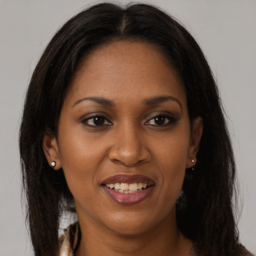 Joyful black young-adult female with long  brown hair and brown eyes