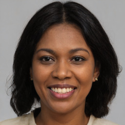 Joyful black young-adult female with medium  brown hair and brown eyes