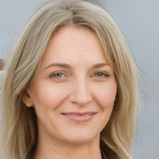 Joyful white adult female with long  brown hair and blue eyes