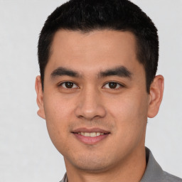 Joyful latino young-adult male with short  brown hair and brown eyes