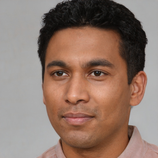 Joyful latino young-adult male with short  black hair and brown eyes