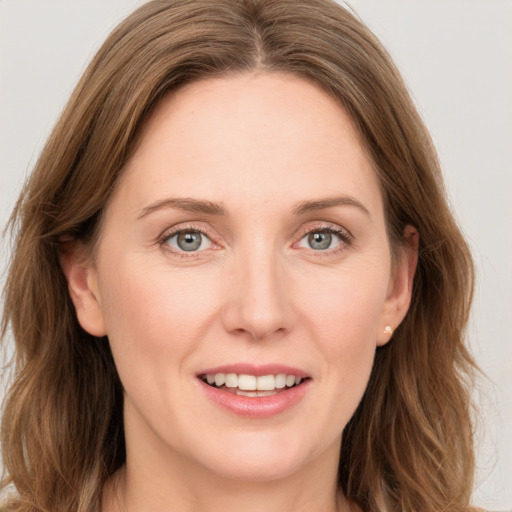 Joyful white young-adult female with long  brown hair and grey eyes