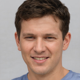 Joyful white young-adult male with short  brown hair and grey eyes