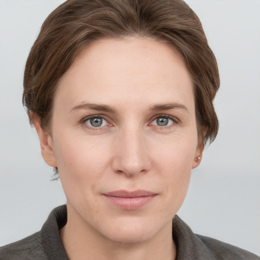 Joyful white young-adult female with short  brown hair and grey eyes