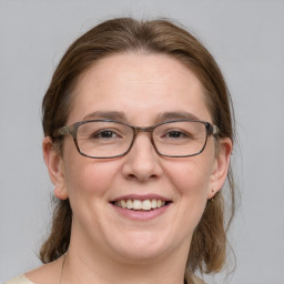 Joyful white adult female with medium  brown hair and blue eyes