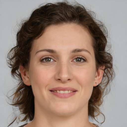 Joyful white young-adult female with medium  brown hair and green eyes