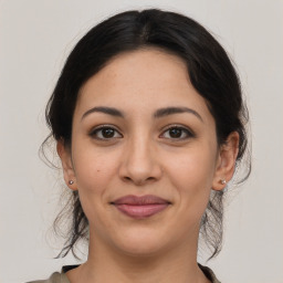 Joyful latino young-adult female with medium  brown hair and brown eyes