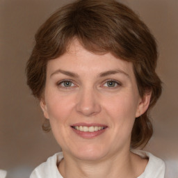 Joyful white adult female with medium  brown hair and grey eyes