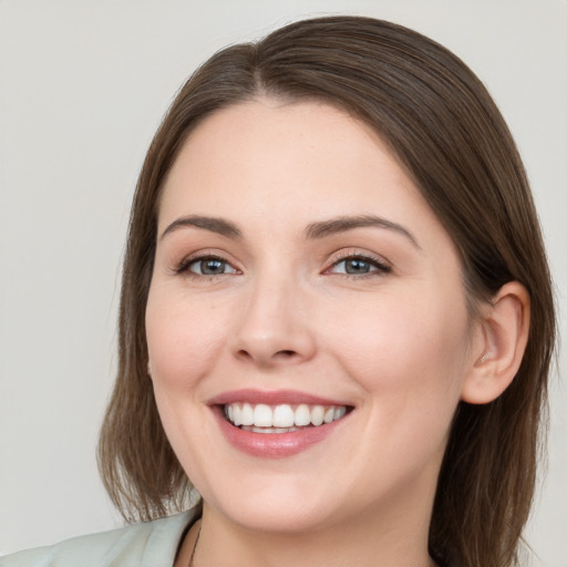 Joyful white young-adult female with long  brown hair and grey eyes