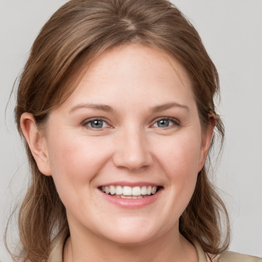 Joyful white young-adult female with medium  brown hair and grey eyes