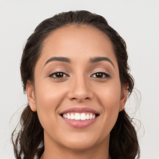 Joyful white young-adult female with long  brown hair and brown eyes