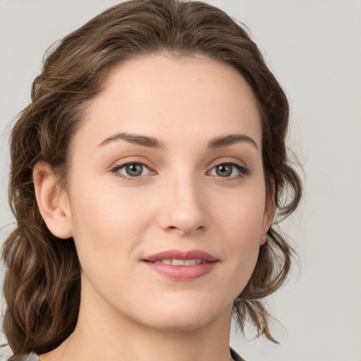 Joyful white young-adult female with medium  brown hair and green eyes