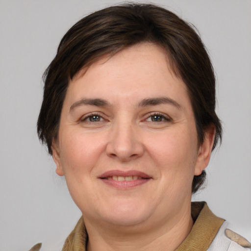 Joyful white adult female with medium  brown hair and grey eyes