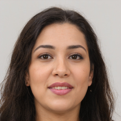 Joyful latino young-adult female with long  brown hair and brown eyes