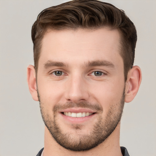 Joyful white young-adult male with short  brown hair and grey eyes