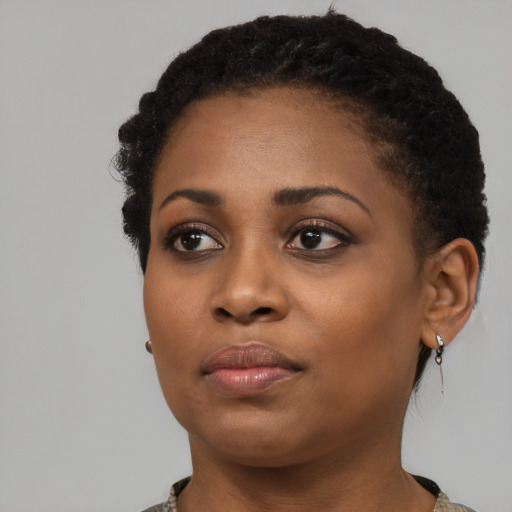 Joyful black young-adult female with short  black hair and brown eyes