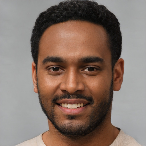 Joyful black young-adult male with short  black hair and brown eyes