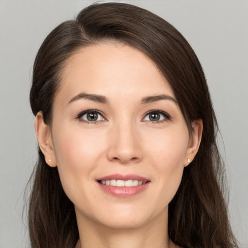 Joyful white young-adult female with long  brown hair and brown eyes