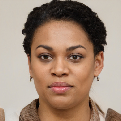 Joyful black young-adult female with short  black hair and brown eyes