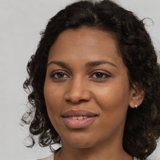 Joyful black young-adult female with medium  brown hair and brown eyes