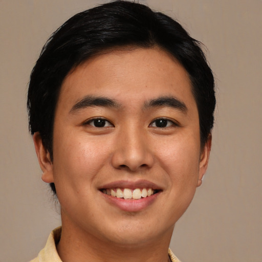 Joyful asian young-adult male with short  brown hair and brown eyes