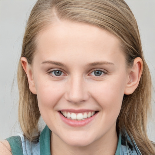 Joyful white young-adult female with long  brown hair and blue eyes