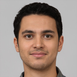 Joyful latino young-adult male with short  brown hair and brown eyes