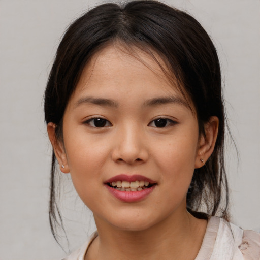 Joyful asian child female with medium  brown hair and brown eyes