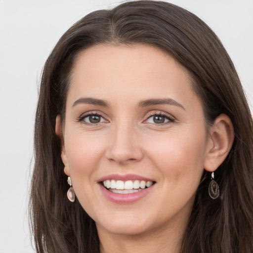 Joyful white young-adult female with long  brown hair and grey eyes