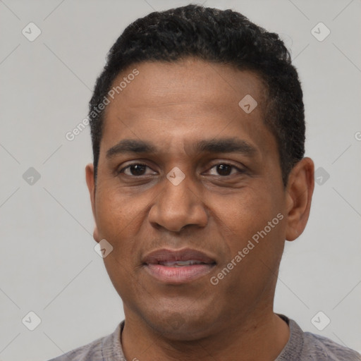 Joyful black adult male with short  black hair and brown eyes