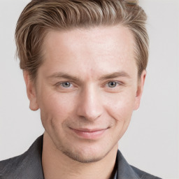 Joyful white young-adult male with short  brown hair and grey eyes