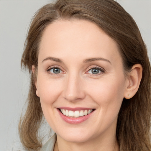 Joyful white young-adult female with long  brown hair and green eyes