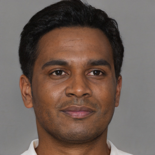 Joyful black young-adult male with short  brown hair and brown eyes