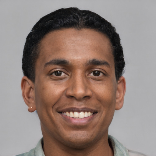 Joyful latino young-adult male with short  black hair and brown eyes